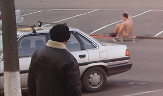 Голый мужчина катался на санках по асфальту Голый мужчина катался на санках по асфальту